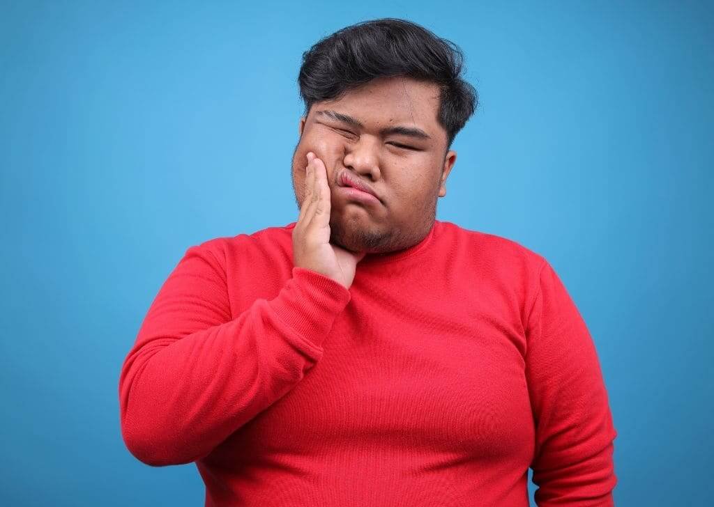 Man is having wisdom tooth pain after removing it at the dentist.